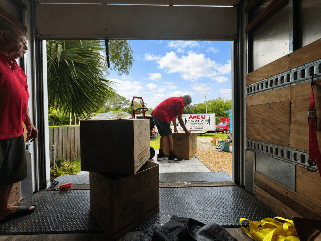 Movers loading boxes into a truck, showing a moving company's services.